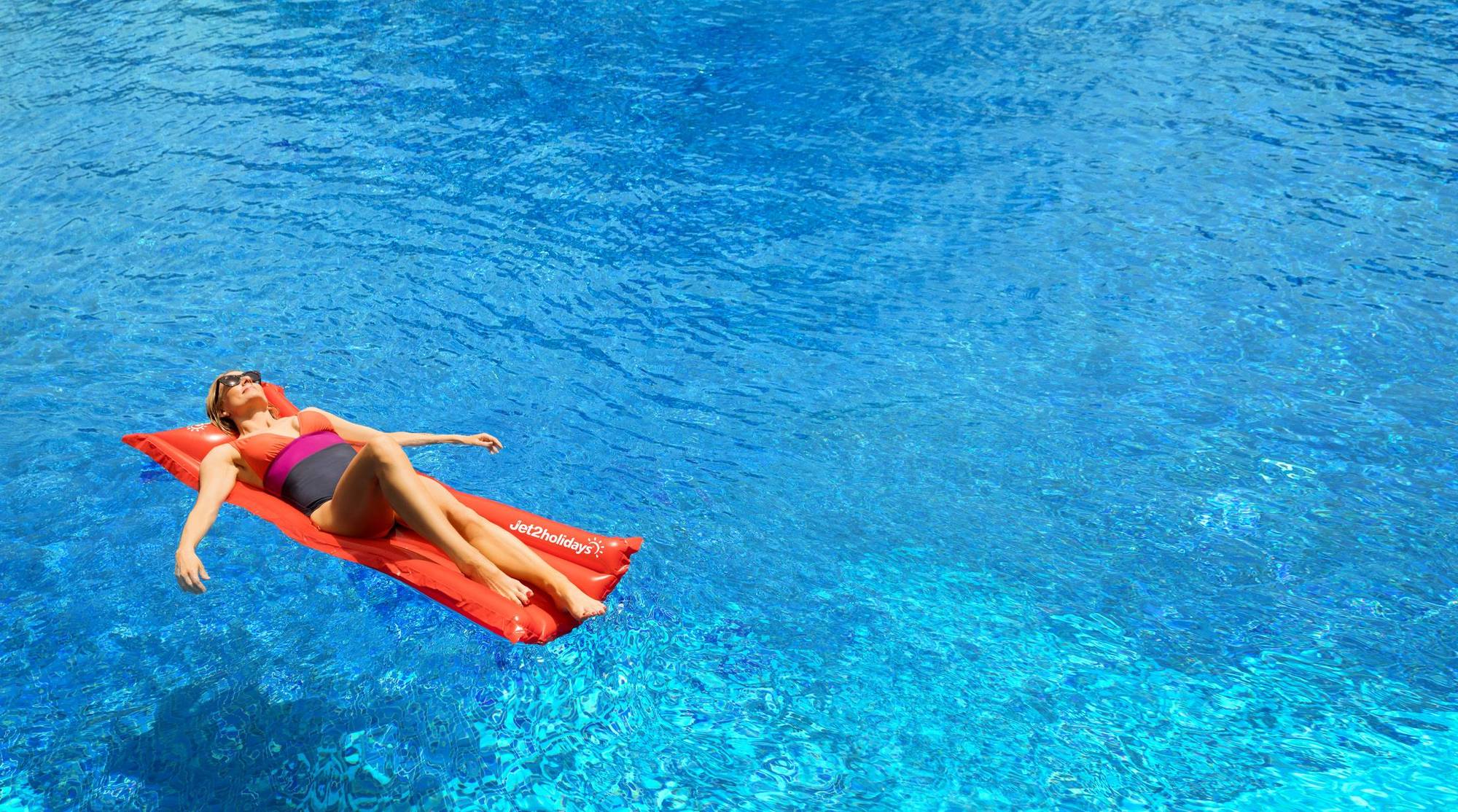 Woman laying on lilo in pool